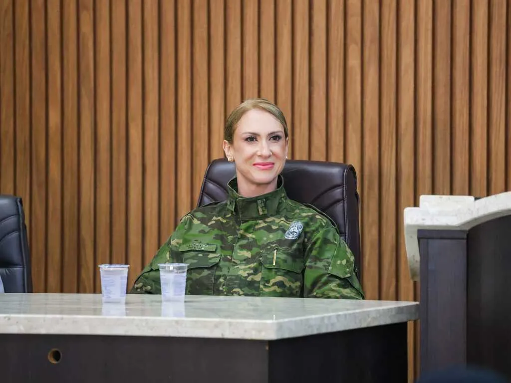 Capitã Patrícia Fernanda Silvério, uniformizada, sentada à mesa durante cerimônia da Polícia Militar Ambiental em Guarapuava.