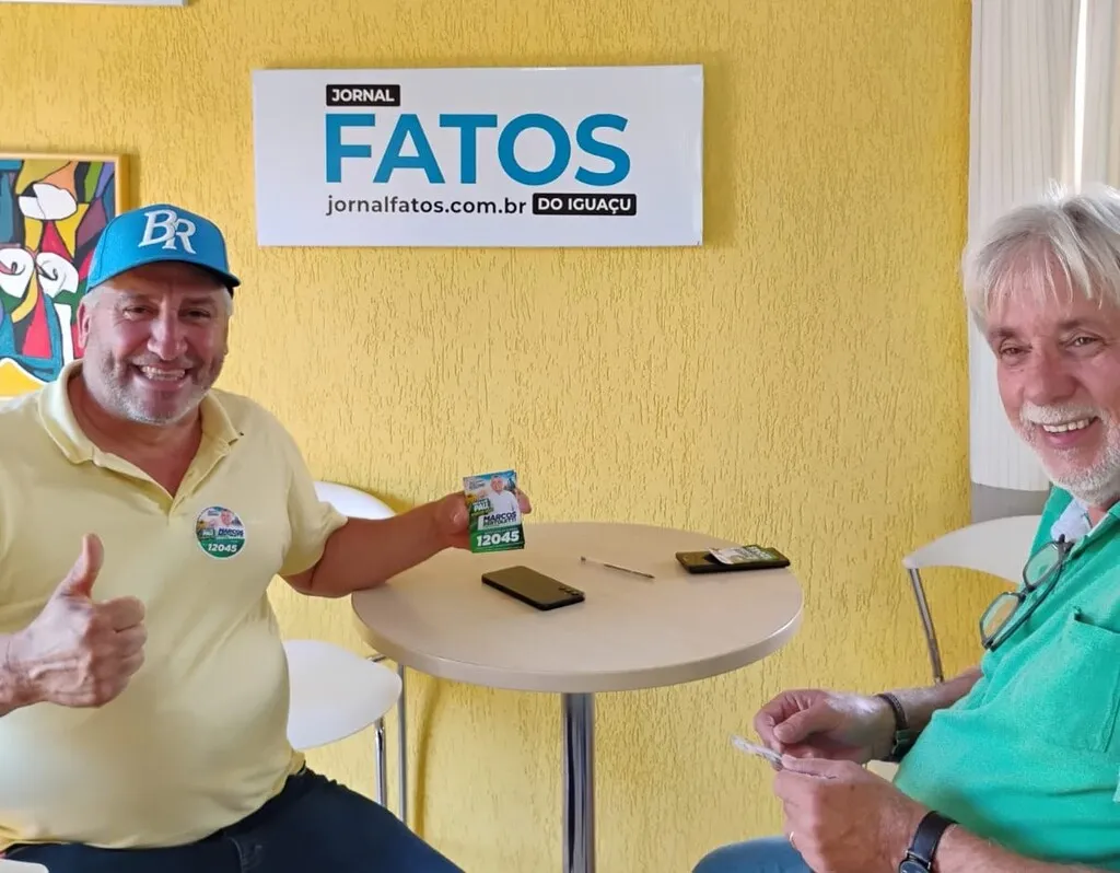 O candidato a deputado estadual Marcos Bertoletti, à esquerda, e o diretor do Portal Fatos do Iguaçu, Naor Coelho, de camiseta polo verde, durante encontro na sede do veículo, em Pinhão.