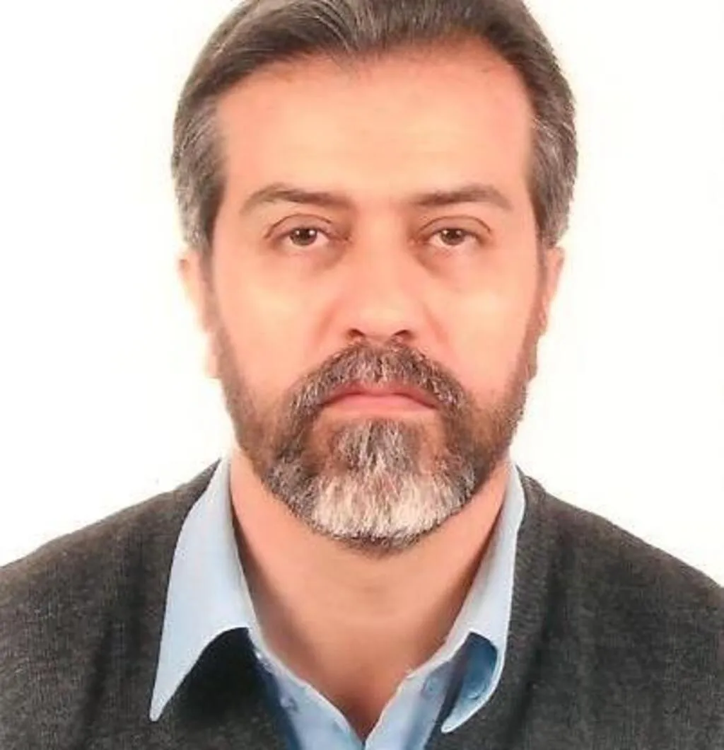 Retrato de Francisco Carlos Caldas, colunista do Portal Fatos do Iguaçu, usando camisa azul e suéter escuro, diante de fundo claro.
